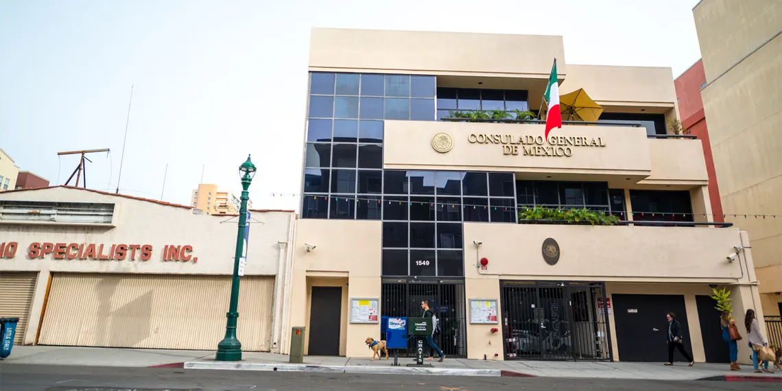 People walking on the street near the entrance to the Consulate of Mexico in San Diego.